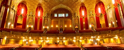 The interior of a beautiful, theatre with red and gold accents.
