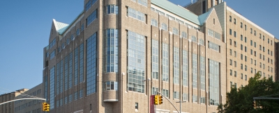 The exterior of a large building on the corner of an intersection.